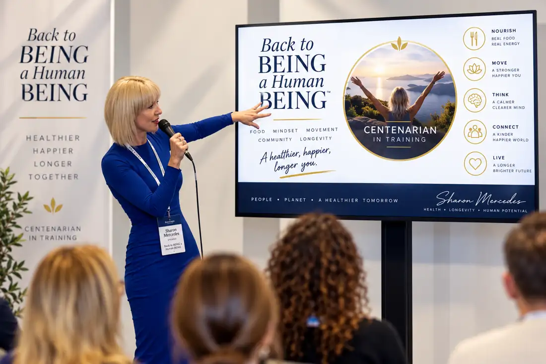Sharon Mercedes speaking into a microphone with a workplace team